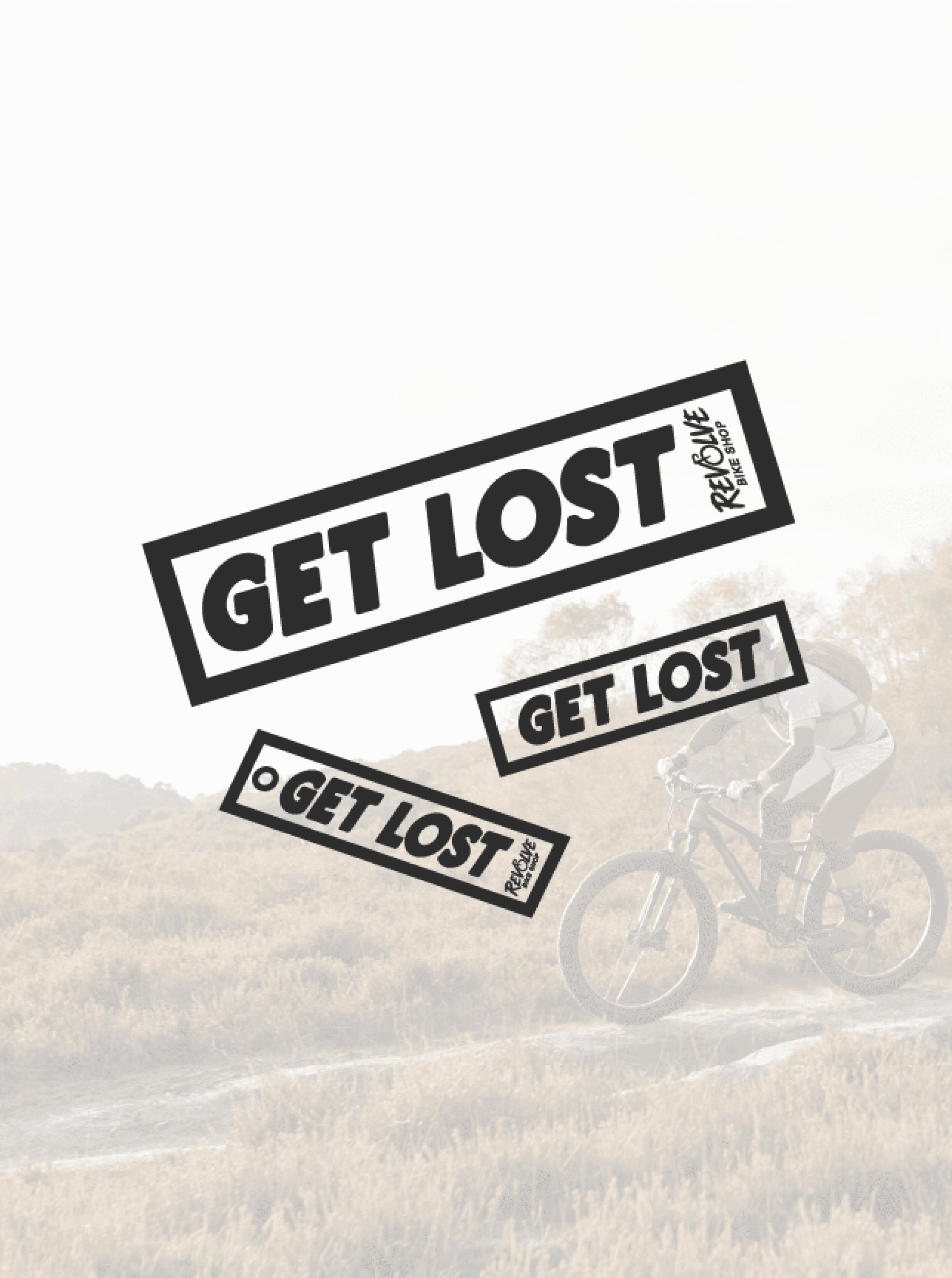 Three angled Get Lost bumper stickers with Revolve branding floating over a faded trail riding photo