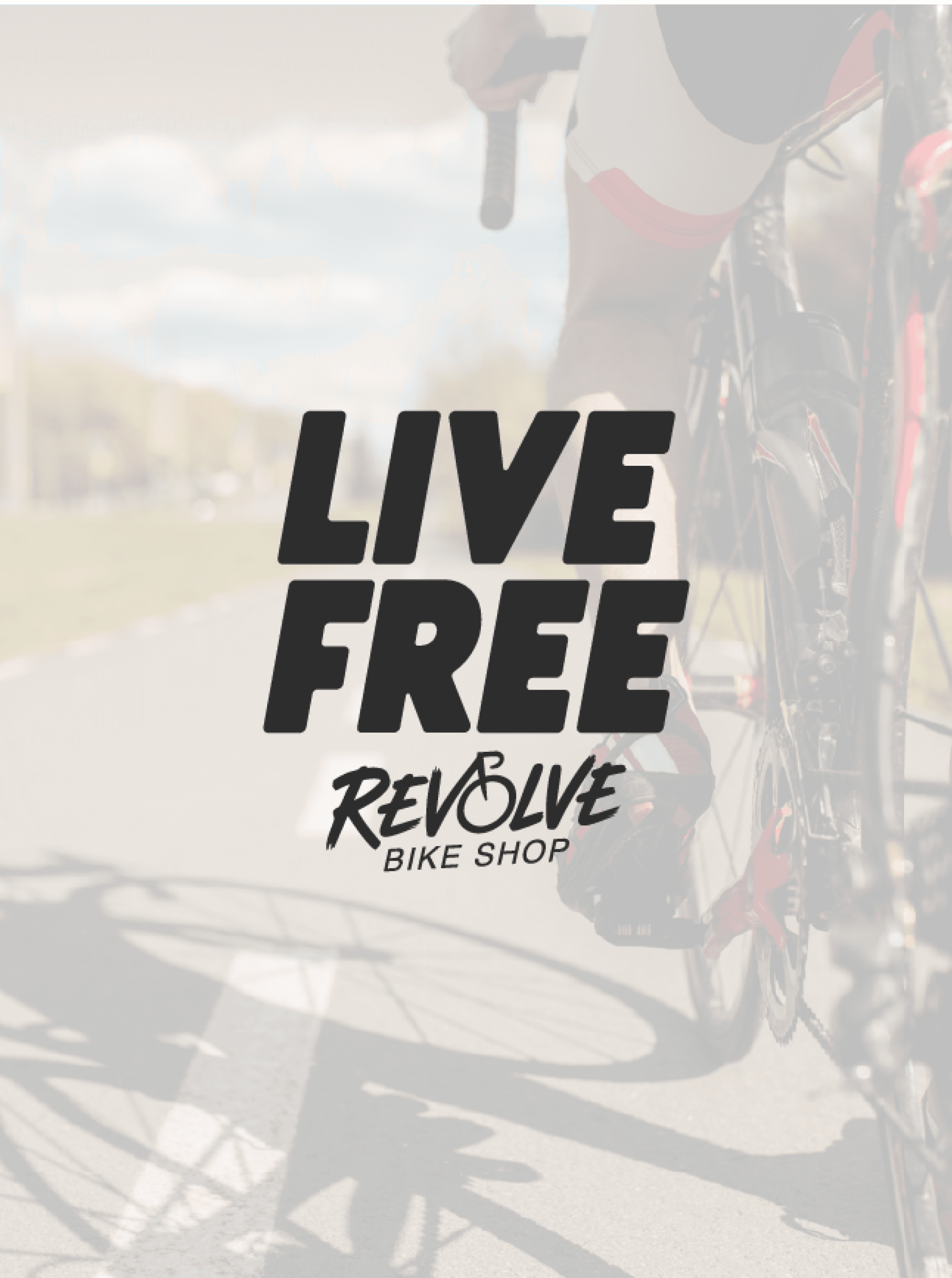 Live Free graphic set over a close crop of a road bike drivetrain and rider's leg, Revolve logo beneath